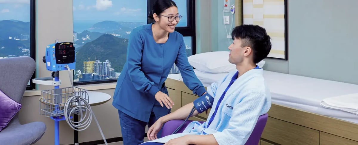 nurse taking blood pressure of male patient